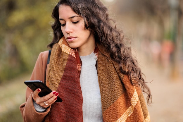 Spanish business woman communicating with smartphone in castilla la mancha toledo fall colors