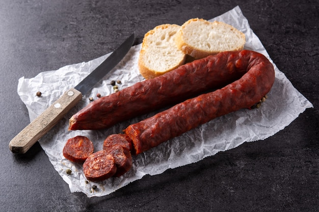 Spanish chorizo sausage on black slate background