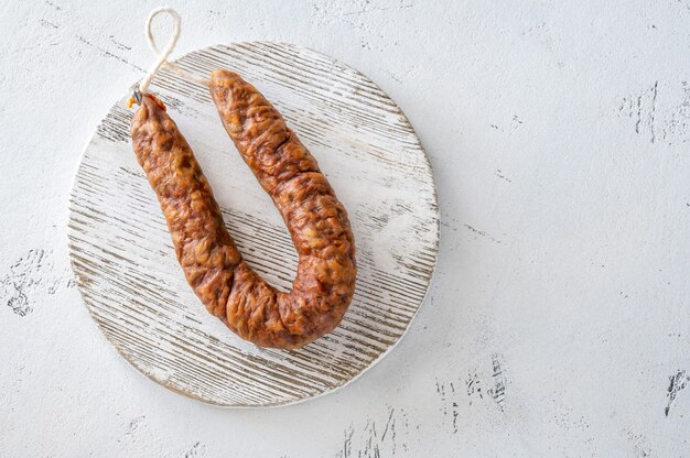 Salsiccia spagnola del chorizo sui precedenti bianchi