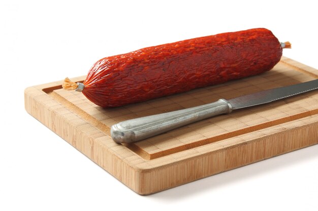 Spanish chorizo sausage with knife on wooden board