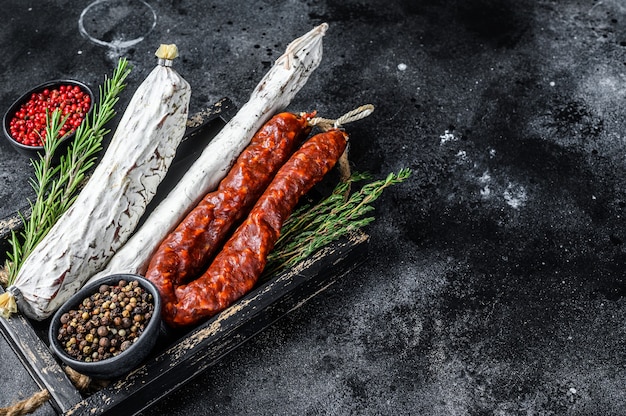 Spanish dry cured sausages salami, fuet and chorizo in a wooden tray