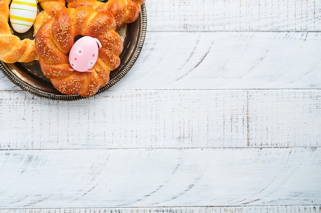 Photo spanish easter cake traditional mona de pascua typical in spain with boiled eggs eaten inside on white rustic wooden table copy space top view mock up