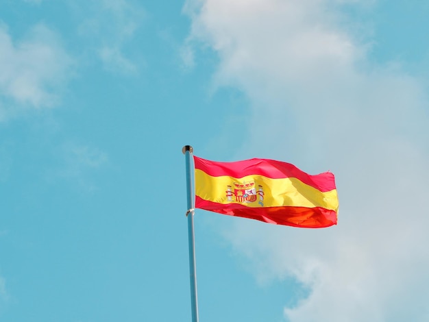 스페인 마드리드에서 바람에 물결치는 깃발 기둥에 스페인 국기 애국심과 자유의 개념