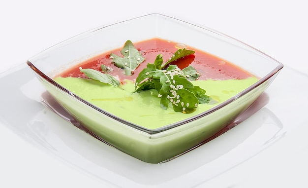 Spanish gazpacho soup With tomatoes and cucumber in a glass dish on white background