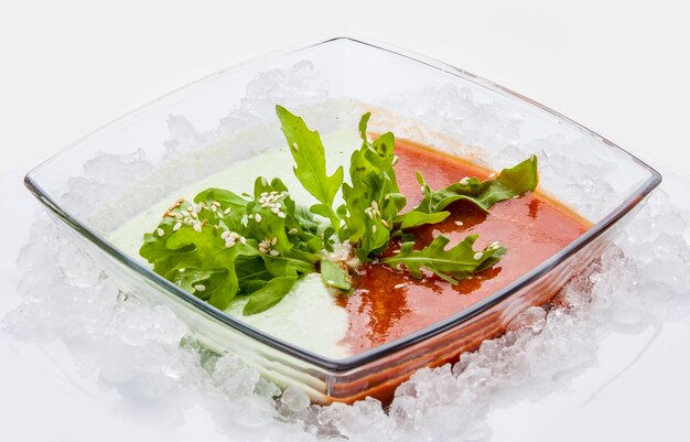 Spanish gazpacho soup With tomatoes and cucumber in a glass dish on white background