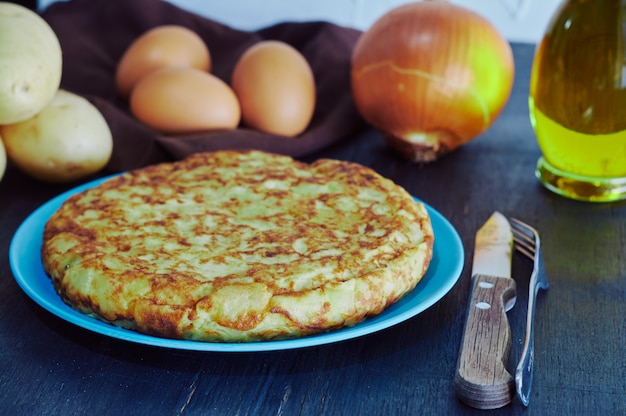 Photo spanish omelette with potato, egg and onion, accompanied by olive oil