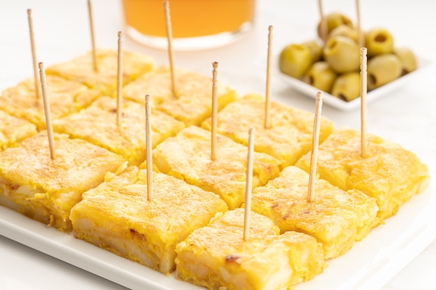 Spanish potato omelette appetizer called spanish tortilla on marble table. Typical spanish tapa