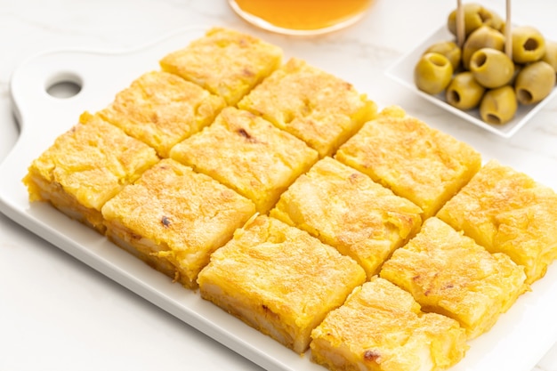 Spanish potato omelette appetizer called spanish tortilla on marble table. Typical spanish tapa