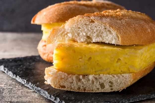 Spanish potato omelette sandwich on wooden table Typical spanish food.