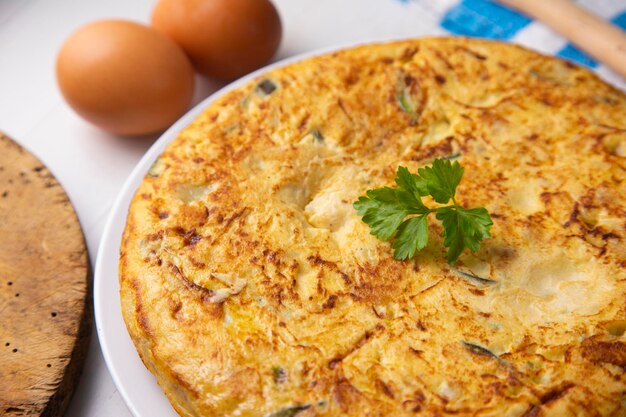 spanish potato omelette with zucchini and young garlic. traditional tapa recipe with egg and potato.
