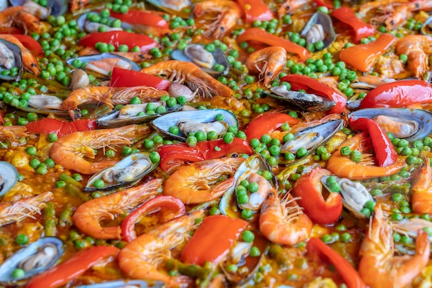 Испанская паэлья из морепродуктов в сковороде с мидиями, креветками и овощами. Фон паэлья из морепродуктов, крупный план, традиционное испанское блюдо из риса