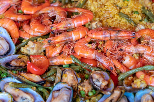 Foto paella spagnola di frutti di mare in padella con cozze gamberetti e verdure sfondo di paella di frutti di mare primo piano tradizionale piatto di riso spagnolo