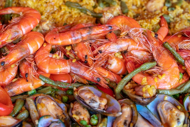 Spanish seafood paella in fry pan with mussels shrimps and vegetables Seafood paella background closeup traditional spanish rice dish