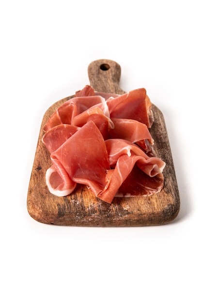 Foto prosciutto spagnolo serrano sul tagliere isolato su priorità bassa bianca