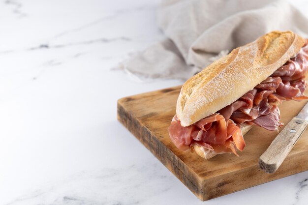 Spanish serrano ham sandwich on marble background