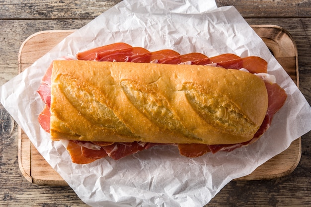 Spanish serrano ham sandwich on wooden table top view