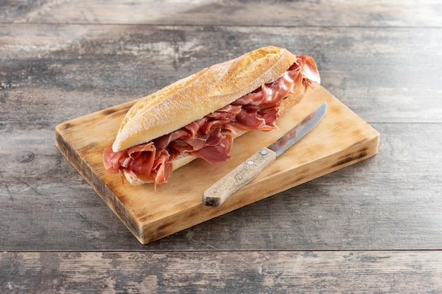 Spanish serrano ham sandwich on wooden table