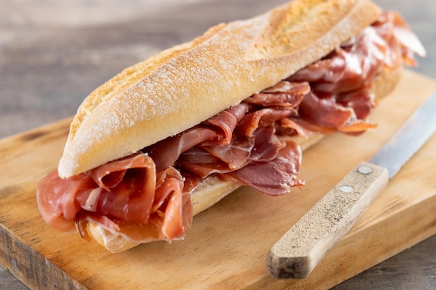 Panino al prosciutto spagnolo di serrano sulla tavola di legno