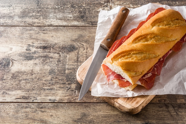 Spanish serrano ham sandwich on wooden table