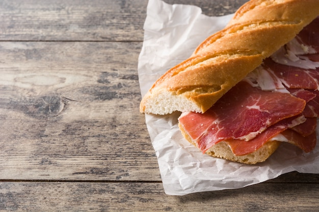 Spanish serrano ham sandwich on wooden table