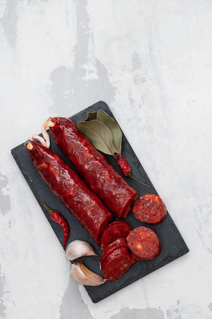 Spanish smoked sausage chorizo on black ceramic board