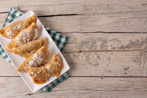 Spanish sweet stuffed pastry filled with angel hair on wooden table