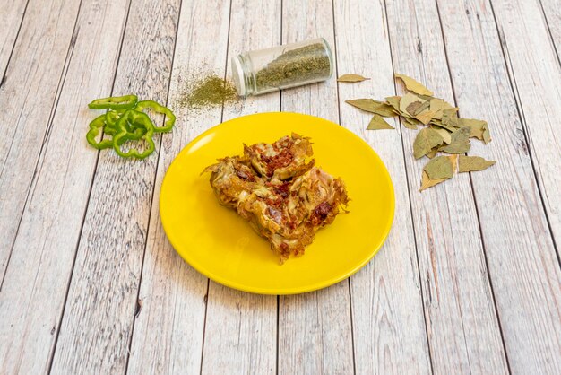 Spanish tapa of artichoke flowers sauteed with fried serrano ham parsley garnishes pepper slices and oregano on light background