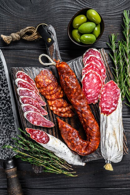 Spanish tapas sliced sausages salami, fuet and chorizo on a wooden cutting board