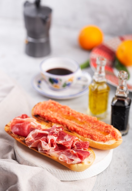 Spanish tomato and ham toast, traditional breakfast or lunch with coffee