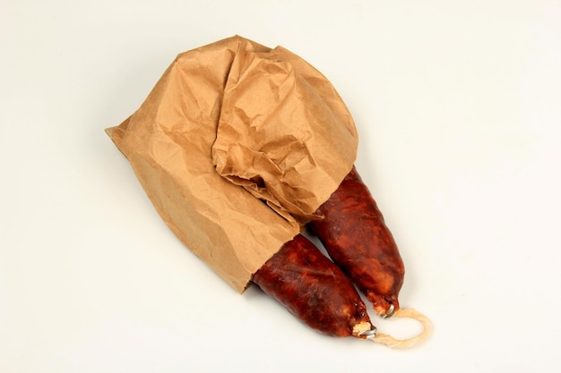 Spanish traditional sausage Chorizo on the crumpled paper on  white  background