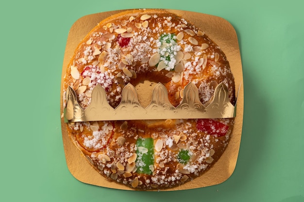 Spanish typical epiphany cake "Roscon de Reyes" on green background