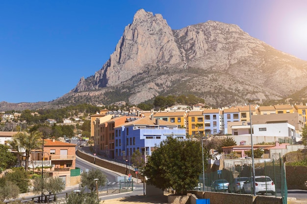 Spanish village with colorful houses at the foot of the puig campana rocks