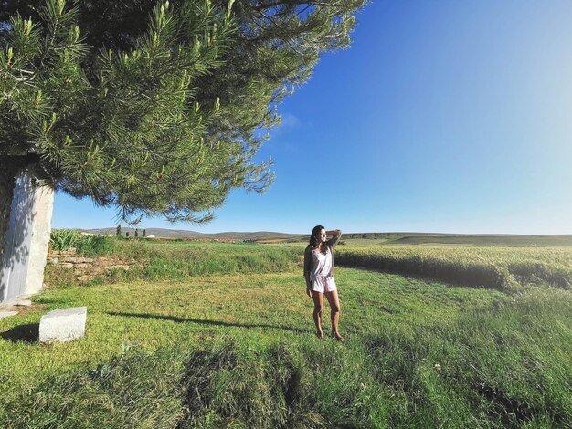 Spanish woman posi in the green valley on a sunny day in summer