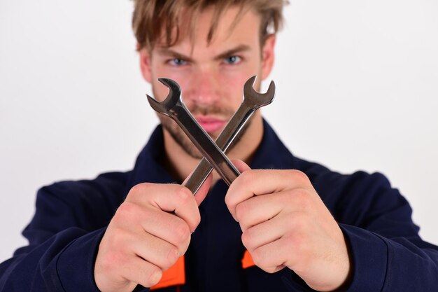 Spanner instrument for fixing or tightening details. man with
serious face holds wrench tools crossed on white background.
service and engineering concept. mechanic or plumber with spanners
in hands