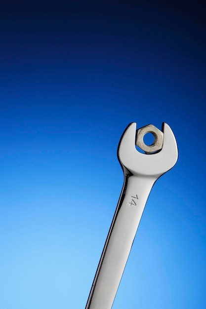 Spanner and nut on the blue background