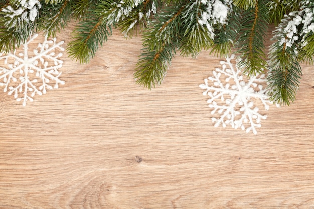 Spar kerstboom bedekt met sneeuw op houten plank achtergrond