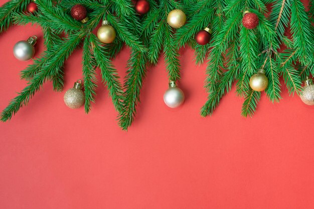 Spar kersttakken, rode en gouden ballen op rode achtergrond. ruimte kopiëren. plat leggen.