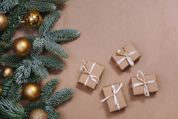 Foto spar takken met kerstversiering en geschenken op kraftpapier achtergrond.