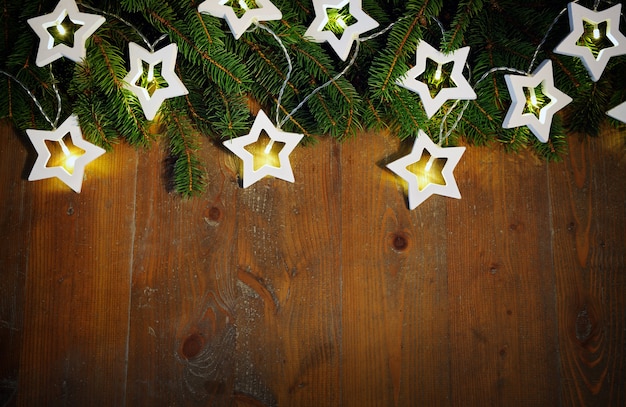 Spar twijgen met kerstverlichting op houten achtergrond