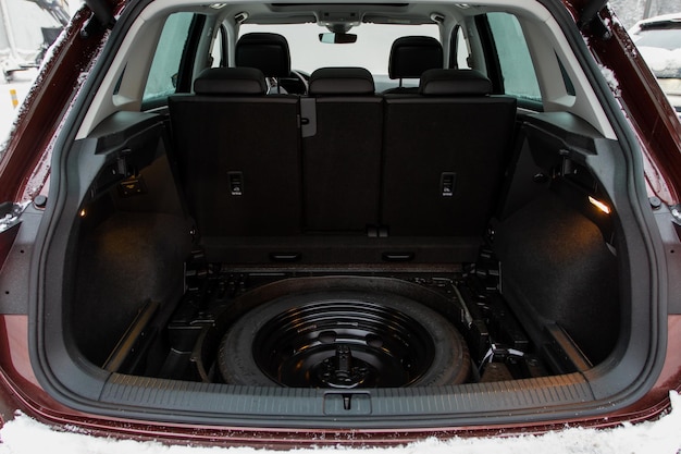 Запасное колесо в багажнике современного автомобиля, подъем домкрата и запасное колесо в задней части автомобиля