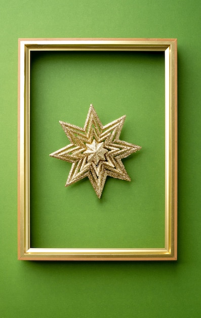 Sparking  christmas star with golden frame on green 