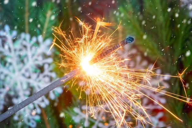 Sparkler and bokeh of Christmas tree on background