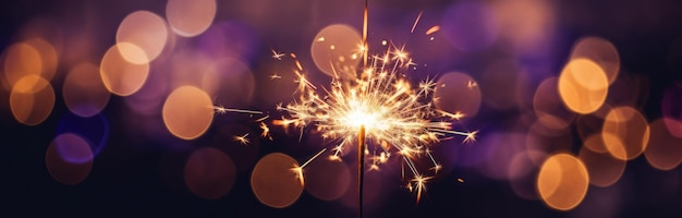 a sparkler burns at a dark night