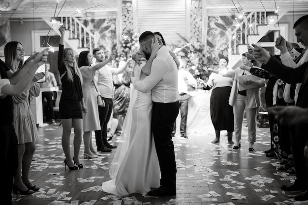 Sparklers at the wedding of the newlyweds in the hands of joyful guests