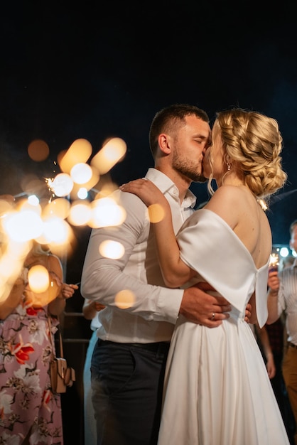 sparklers at the wedding of the newlyweds in the hands of joyful guests