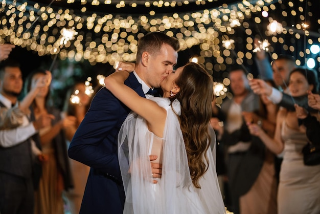 Sparklers at the wedding of the newlyweds in the hands of joyful guests