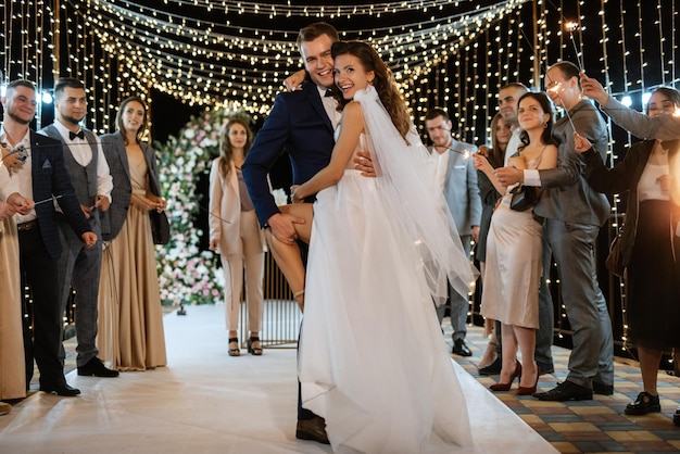 Sparklers at the wedding of the newlyweds in the hands of joyful guests