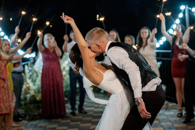 Photo sparklers at the wedding of the newlyweds in the hands of joyful guests