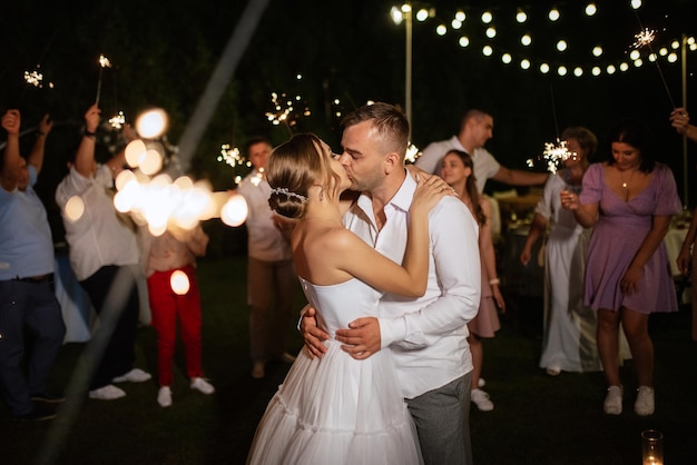 Sparklers at the wedding of the newlyweds in the hands of joyful guests