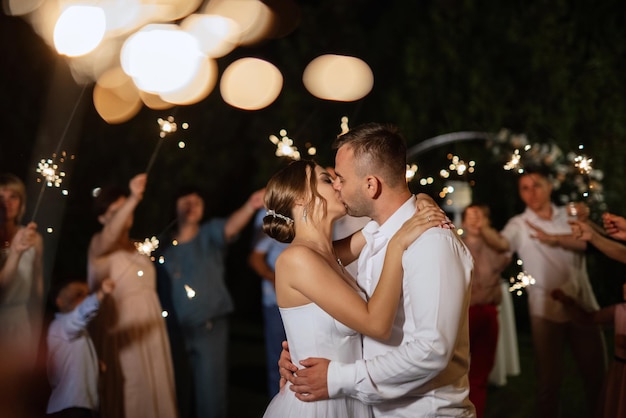 Sparklers at the wedding of the newlyweds in the hands of joyful guests